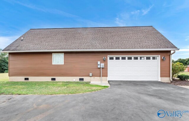 view of property exterior with a garage and a lawn