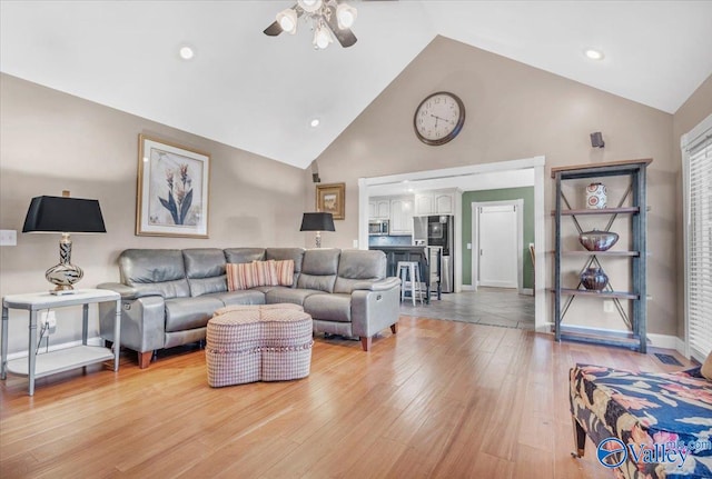 living room with high vaulted ceiling, light hardwood / wood-style floors, and ceiling fan