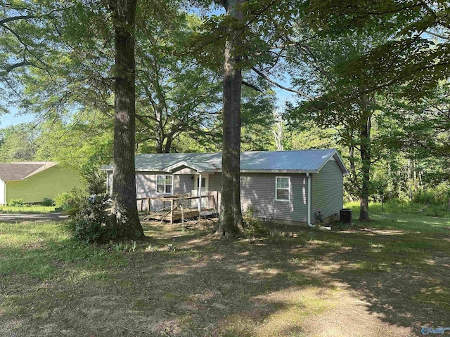 exterior space with central AC, a wooden deck, and metal roof
