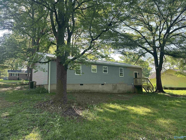 view of side of property featuring a lawn, crawl space, and central AC unit