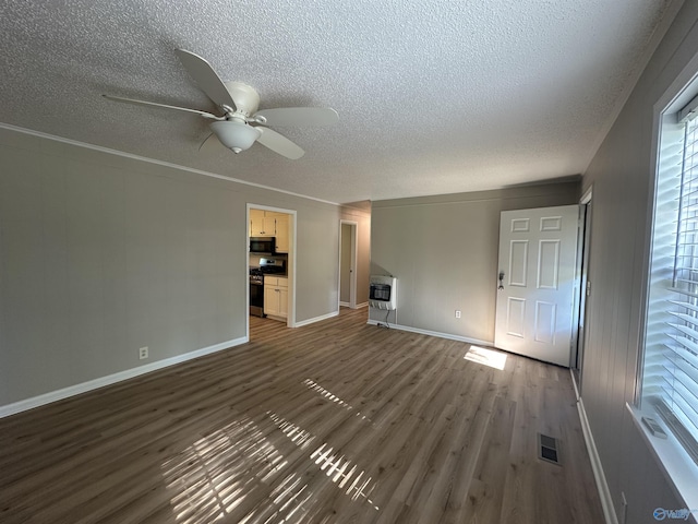 unfurnished living room featuring dark wood finished floors, visible vents, a ceiling fan, and a textured ceiling