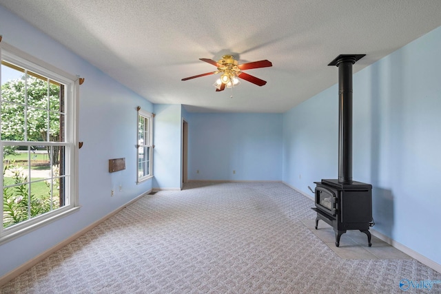 114 Butch Cir, Hazel Green, AL 35750 - unfurnished living room featuring a wood stove, ceiling fan, light carpet, and a textured ceiling