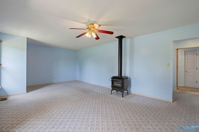 114 Butch Cir, Hazel Green, AL 35750 - unfurnished living room with carpet, ceiling fan, a wood stove, and a textured ceiling
