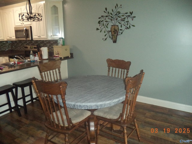 dining room with baseboards and dark wood finished floors