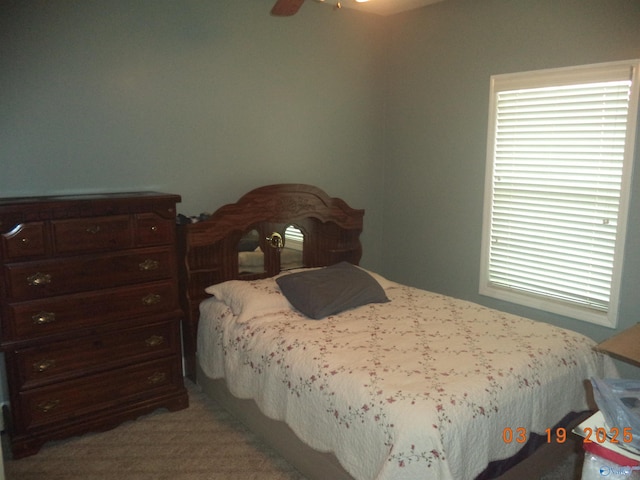 bedroom with light carpet, multiple windows, and a ceiling fan