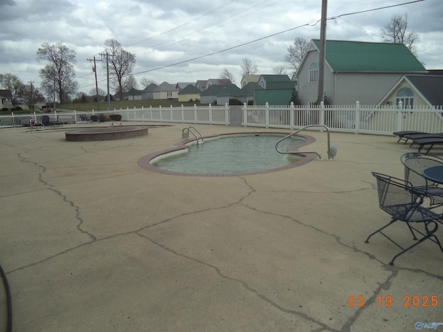 community pool featuring a patio area and fence
