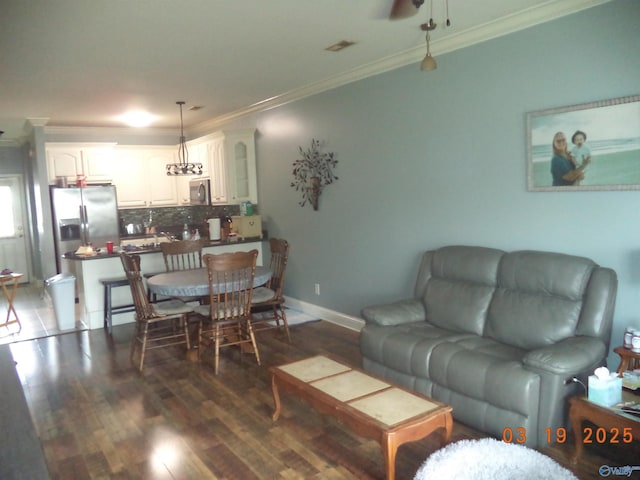 living room with baseboards, wood finished floors, and crown molding