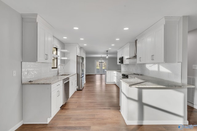 kitchen with sink, stainless steel appliances, light stone counters, backsplash, and white cabinets