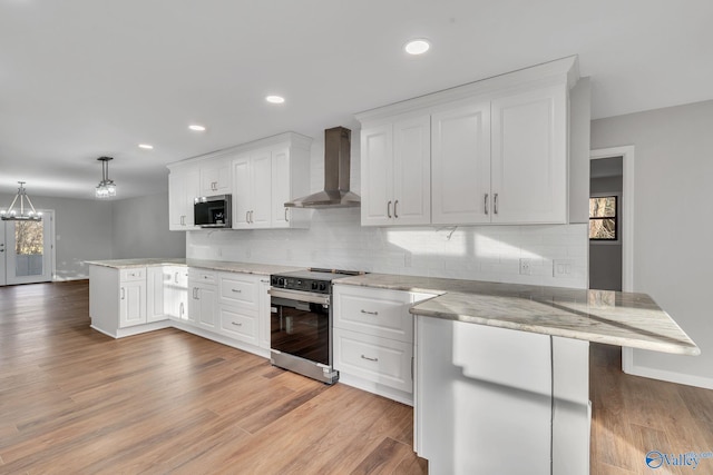 kitchen with wall chimney exhaust hood, white cabinetry, kitchen peninsula, and stainless steel appliances