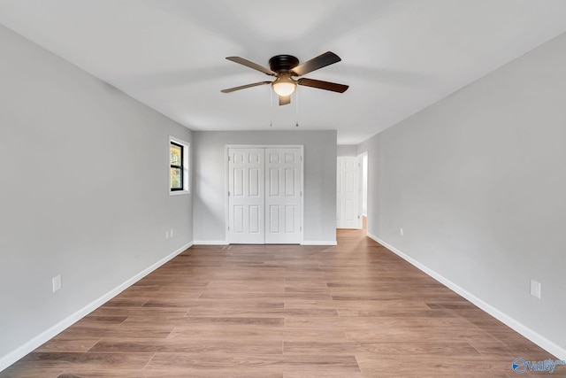 unfurnished bedroom with ceiling fan, a closet, and light hardwood / wood-style flooring