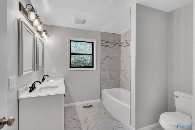 full bathroom with tiled shower / bath, vanity, and toilet