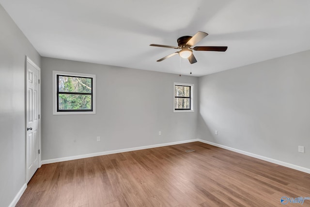 spare room featuring a wealth of natural light, light hardwood / wood-style flooring, and ceiling fan