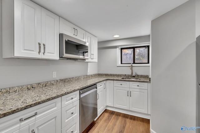 kitchen featuring light stone countertops, sink, white cabinetry, and stainless steel appliances