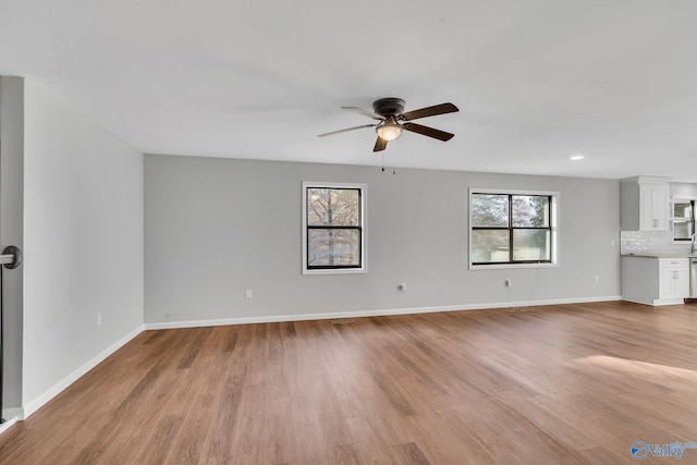 unfurnished living room with ceiling fan and light wood-type flooring