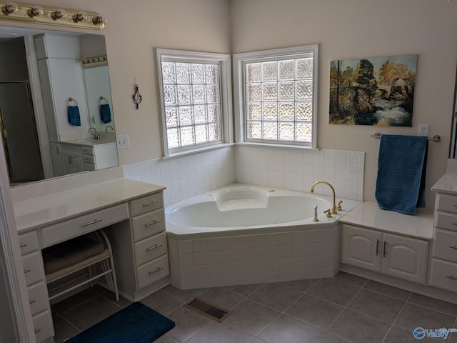 bathroom with a garden tub, visible vents, vanity, and tile patterned floors