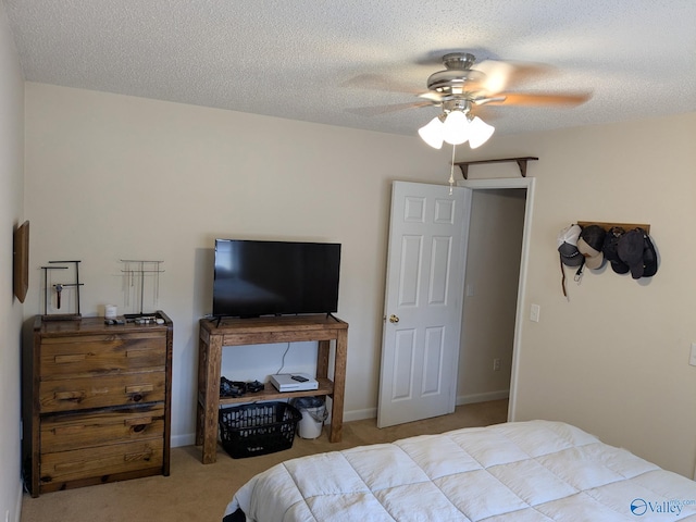 carpeted bedroom featuring a textured ceiling, ceiling fan, and baseboards