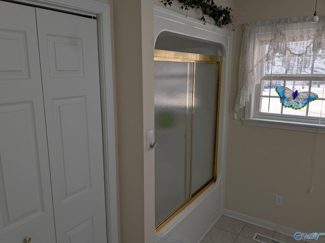 bathroom with enclosed tub / shower combo, visible vents, baseboards, and tile patterned floors