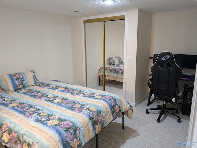 carpeted bedroom with a closet, baseboards, and a textured ceiling