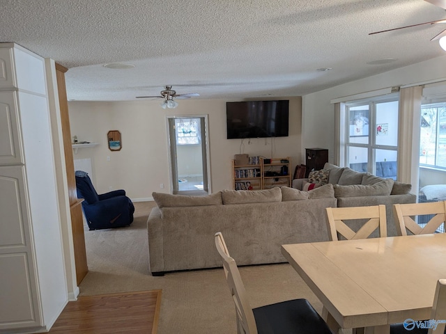 living area with a healthy amount of sunlight, carpet, ceiling fan, and a textured ceiling