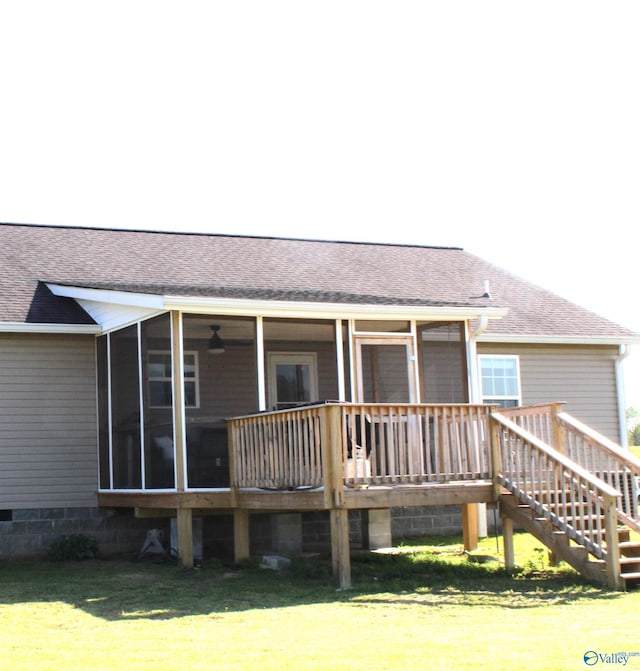 back of property featuring a lawn, a shingled roof, and a sunroom