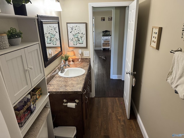 bathroom featuring vanity, baseboards, toilet, and wood finished floors