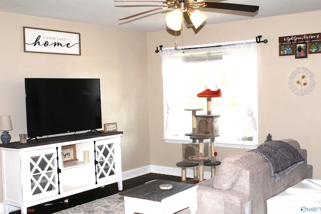 living room with baseboards, a ceiling fan, and wood finished floors