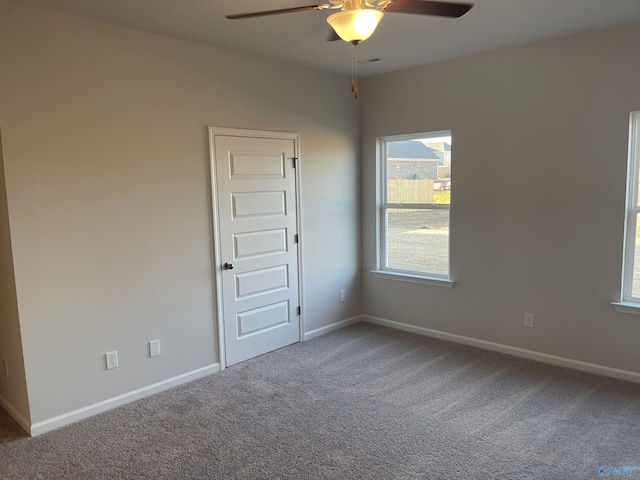 carpeted spare room featuring ceiling fan