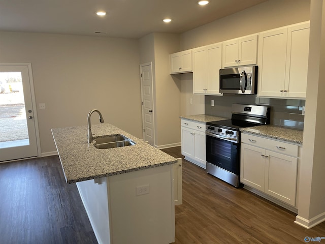 kitchen with sink, white cabinetry, an island with sink, stainless steel appliances, and light stone countertops