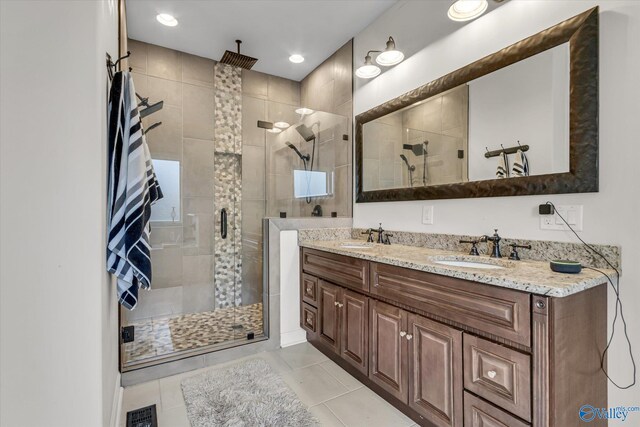 full bath with a stall shower, visible vents, a sink, and double vanity