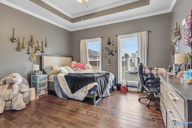 bedroom with ornamental molding, dark wood-style flooring, and a raised ceiling