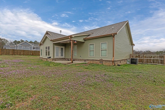 rear view of property featuring a fenced backyard, a shingled roof, a patio, and a yard