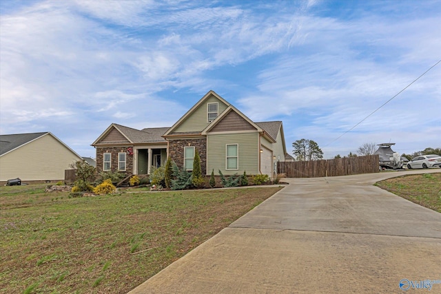 view of front facade featuring fence, a front lawn, and concrete driveway