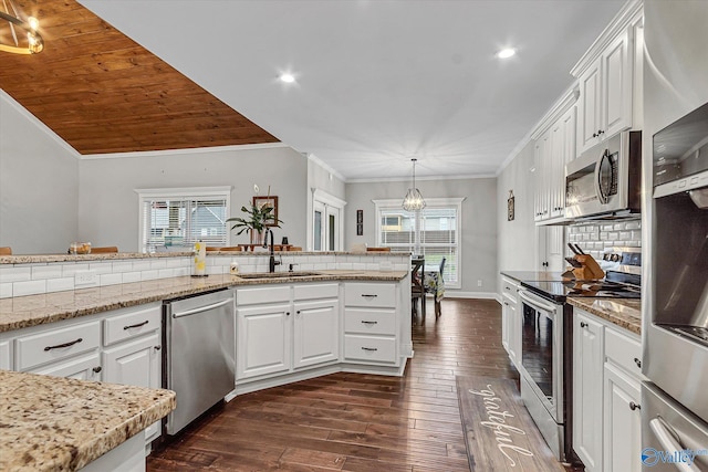 kitchen featuring hanging light fixtures, white cabinetry, appliances with stainless steel finishes, and a sink