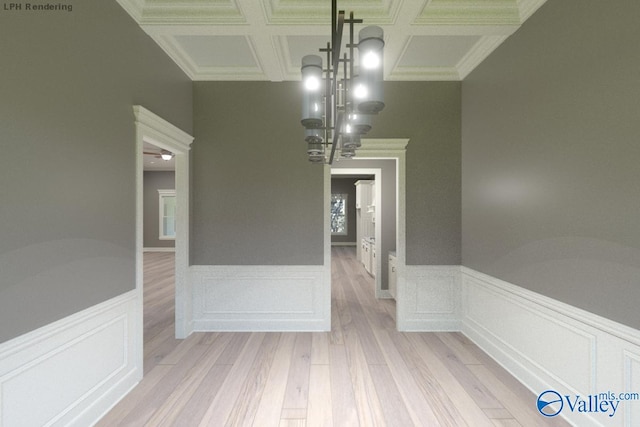 unfurnished dining area featuring beam ceiling, light wood-type flooring, coffered ceiling, and ornamental molding