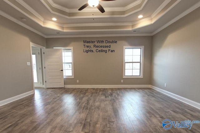 unfurnished room featuring a raised ceiling, dark wood-type flooring, and ornamental molding