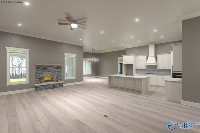 kitchen with white cabinetry, tasteful backsplash, a fireplace, a kitchen island, and custom exhaust hood