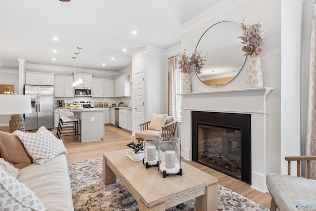 living room featuring crown molding and light hardwood / wood-style floors