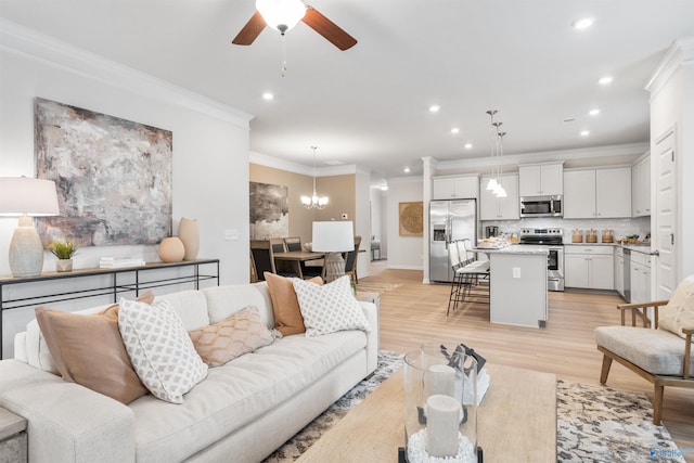 living room featuring crown molding, light hardwood / wood-style flooring, and ceiling fan with notable chandelier