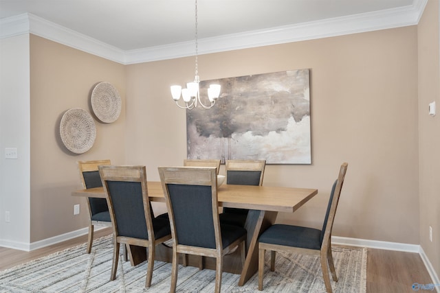 dining space featuring an inviting chandelier, ornamental molding, and hardwood / wood-style floors