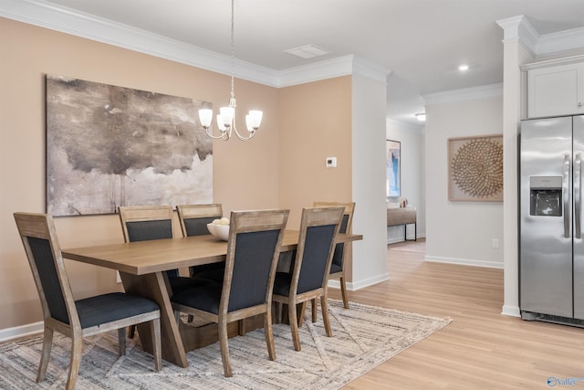 dining area with an inviting chandelier, ornamental molding, and light hardwood / wood-style flooring