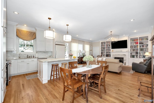 dining space with crown molding and light hardwood / wood-style floors