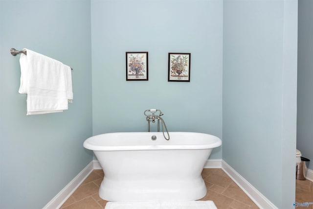 bathroom with a tub to relax in and tile patterned floors