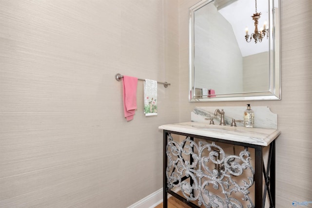 bathroom with sink and a notable chandelier