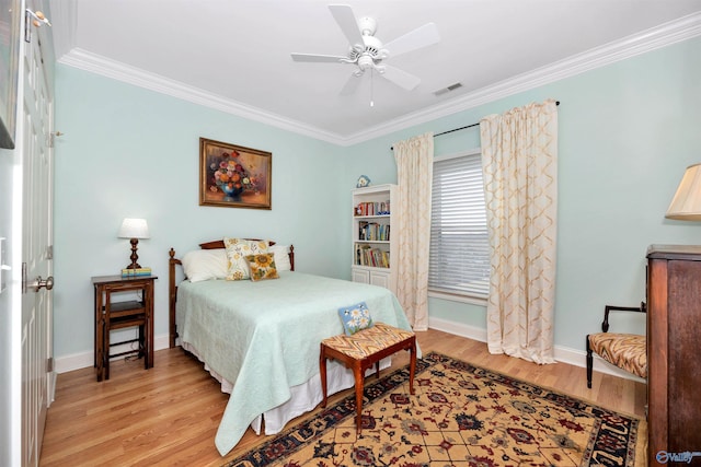 bedroom with ornamental molding, ceiling fan, and light hardwood / wood-style floors