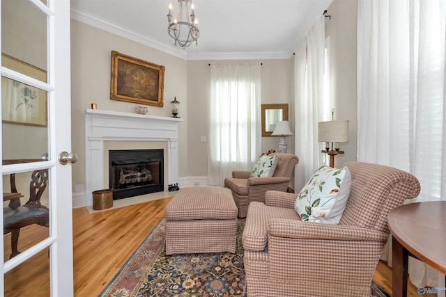 living area with an inviting chandelier, ornamental molding, and hardwood / wood-style floors