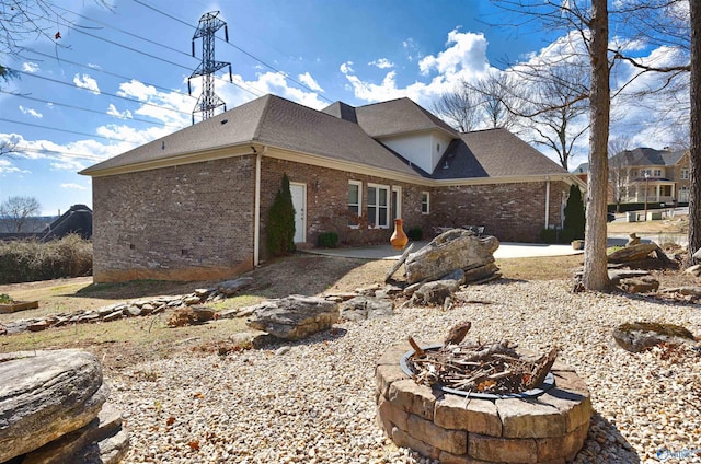 back of property with a patio area and an outdoor fire pit