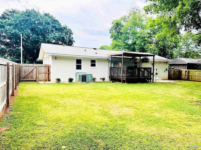 rear view of property featuring central air condition unit, a yard, and a patio