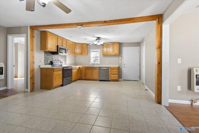 kitchen featuring tasteful backsplash, heating unit, sink, and stainless steel appliances