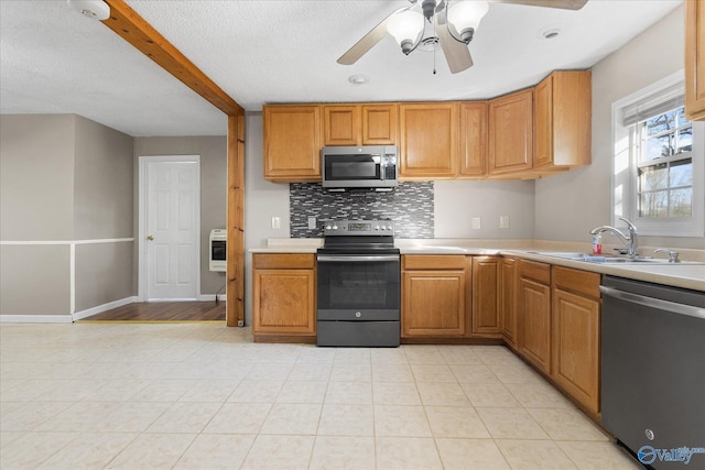 kitchen with ceiling fan, sink, stainless steel appliances, backsplash, and heating unit