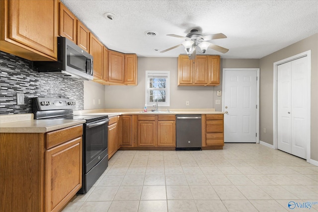 kitchen featuring ceiling fan, sink, appliances with stainless steel finishes, and tasteful backsplash